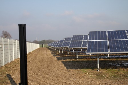 Solarpanels stehen auf einem umzäunten Gelände, es sind an den Grundstücksecken Sensoren für die Freilandüberwachung aufgestellt